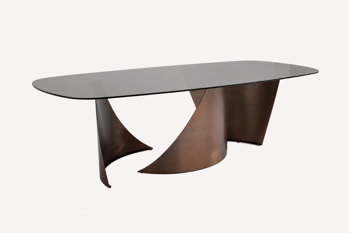 Oval smoked glass dining table on sculptural brushed bronze steel base