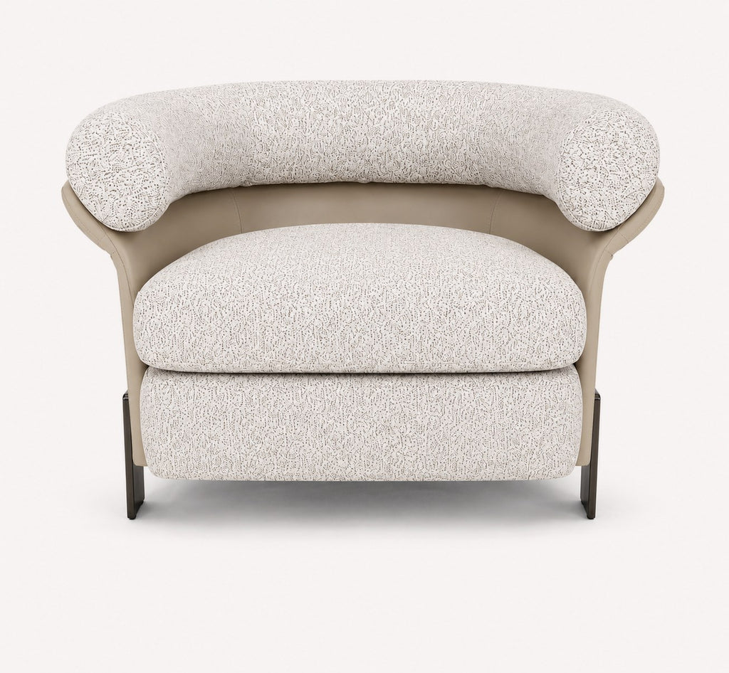 Aristo rounded accent chair with leather exterior and metal legs